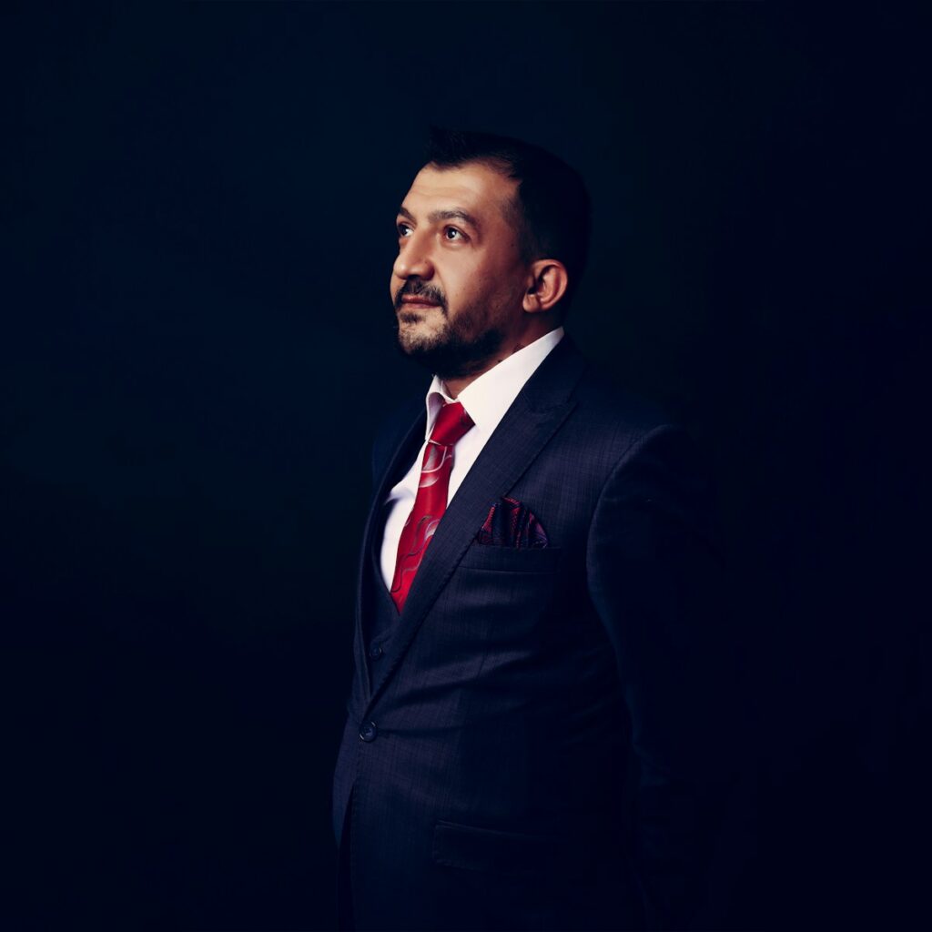 a man in a suit and red tie